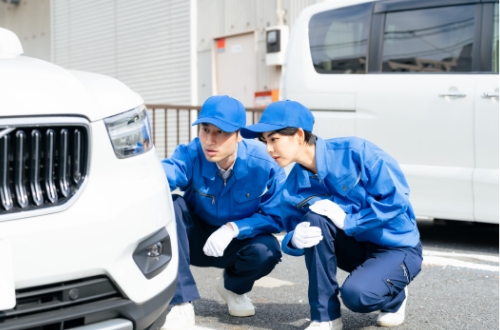 男性が２人で車の点検をしている様子